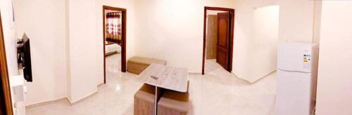 a room with a kitchen with a table and a refrigerator at RAWA'AT ALAQABA in Aqaba