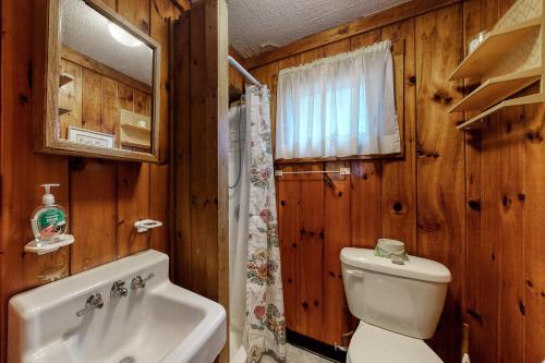 La salle de bains est pourvue de toilettes, d'un lavabo et d'un miroir. dans l'établissement Otis Cottages, à York