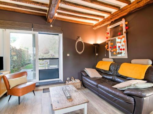 ein Wohnzimmer mit einem Ledersofa und einem Fenster in der Unterkunft Traditional Cottage with private terrace in Amas
