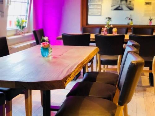 a dining room with a wooden table and chairs at Haus Mees Apartments in Wuppertal