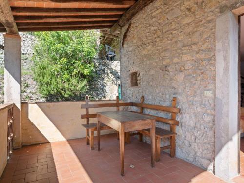 Belvilla by OYO Camelia في Pescaglia: طاولة خشبية ومقعد على الفناء