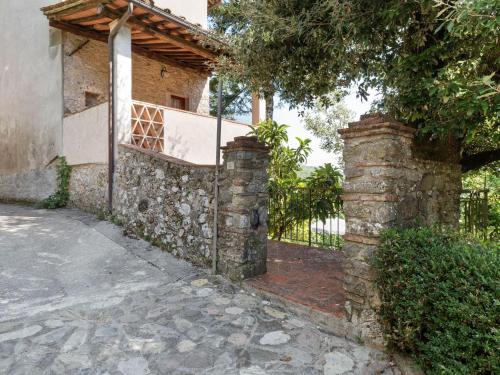 a stone fence in front of a house at Belvilla by OYO Camelia in Pescaglia