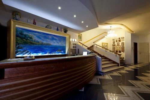 a lobby with a large painting on the wall at Hotel Riva Del Sole in Cefalù