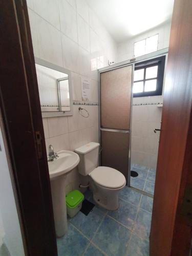 a small bathroom with a toilet and a sink at Casa Praia Itanhaém in Itanhaém