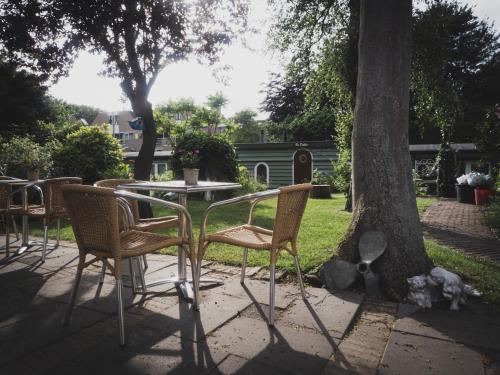 a picnic table with chairs and a lawn chair at B&B Het Ruime Sop in Wassenaar