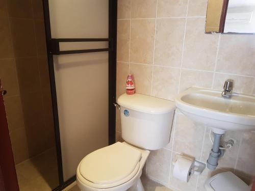 a bathroom with a toilet and a sink at Hotel Don Juan Colonial in Floridablanca