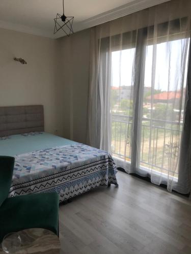 1 dormitorio con cama y ventana grande en Teoscitta Apart, en Seferihisar