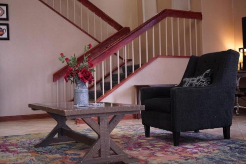 a living room with a chair and a table with a vase of flowers at Baymont by Wyndham Shakopee in Shakopee