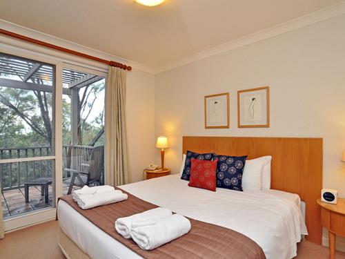 ポーコルビンにあるVilla 1br Merlot Villa located within Cypress Lakes Resortのベッドとタオル2枚のある寝室