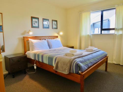 een slaapkamer met een groot bed en handdoeken bij Beech Cottage - Lake Tekapo in Lake Tekapo