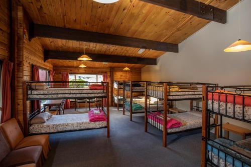 a room with several bunk beds in a cabin at Te Anau Top 10 Holiday Park and Motels in Te Anau