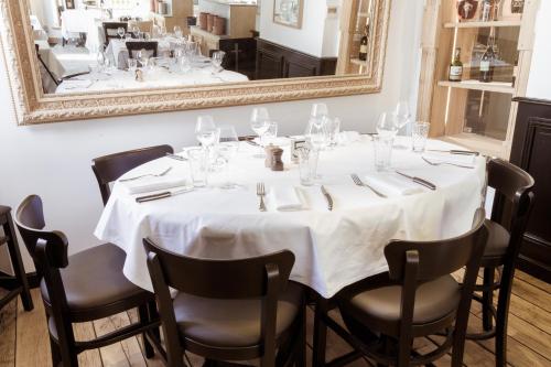 a dining room with a table with a mirror at Hôtel et Spa La Villa K - Basel Airport in Saint-Louis