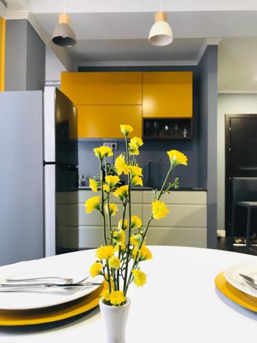 a kitchen with yellow flowers in a vase on a table at VNVP Apartment in Štip