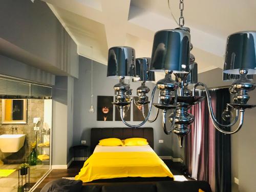 a bedroom with a yellow bed and a chandelier at VNVP Apartment in Štip