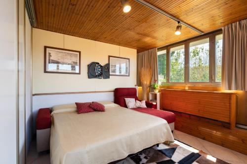 een slaapkamer met een bed, een bank en ramen bij Suite in Villa La Fenice in Monsummano