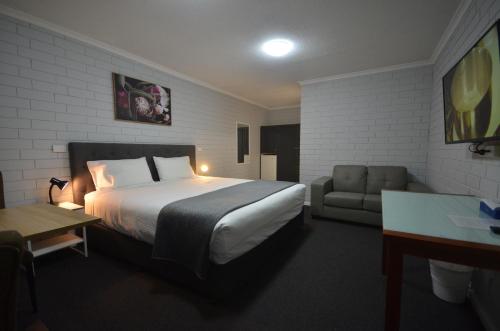 a hotel room with a bed and a couch at Frewville Motor Inn in Adelaide