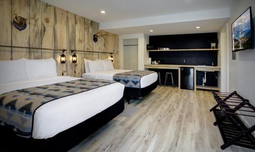 a hotel room with two beds and a desk at Outdoors Inn in Sandpoint
