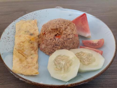 a plate of food with rice and vegetables on a table at Pasola in Tambolaka