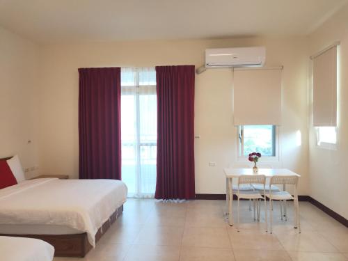 a bedroom with a bed and a table with chairs at 響樂池上電梯民宿1663 Chishang Music Guesthouse in Chishang
