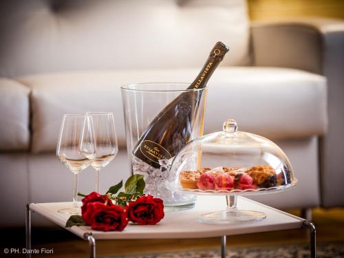 a table with a bottle of wine and two glasses at Schio Hotel in Schio