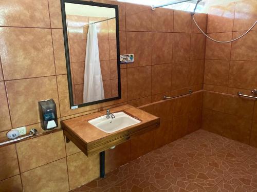 ein Bad mit einem Waschbecken und einem Spiegel in der Unterkunft Hotel Uran in Rivas