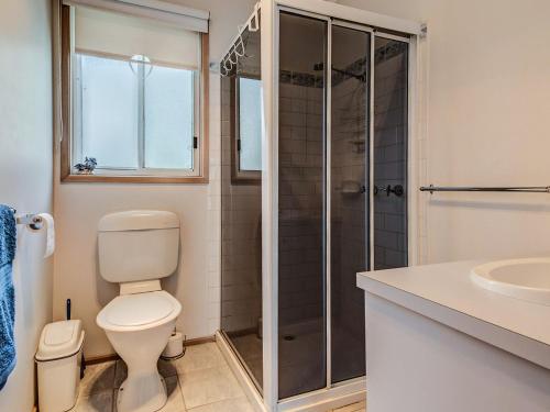 a bathroom with a shower and a toilet and a sink at Colonnades in Cape Woolamai