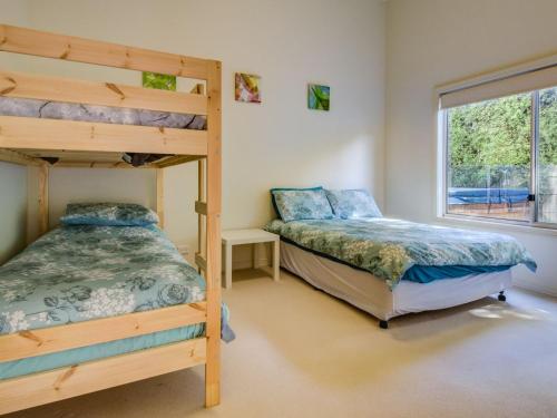 a bedroom with two bunk beds and a window at Cuttriss by the Beach in Inverloch