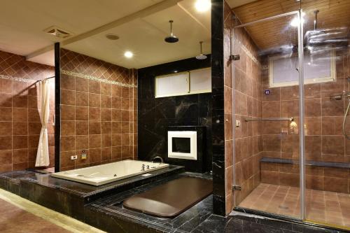 a large bathroom with a tub and a shower at Vogue Boutique Motel in Yangmei