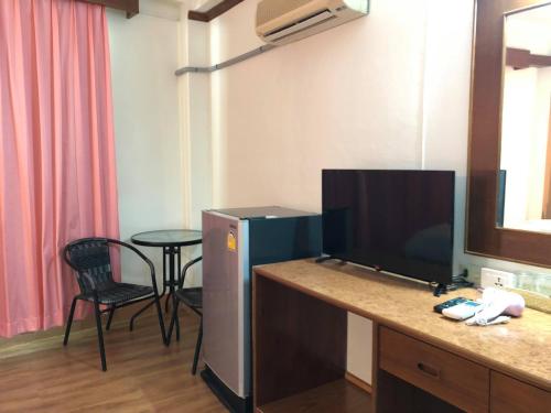 a room with a desk with a tv and a table at Betong Hill Hotel โรงแรมเบตง ฮิลล์ in Betong
