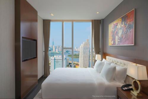 a hotel room with a large bed and a large window at Sedona Suites Ho Chi Minh City in Ho Chi Minh City