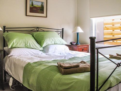1 dormitorio con 1 cama grande con sábanas verdes en Redwood, en Cowes