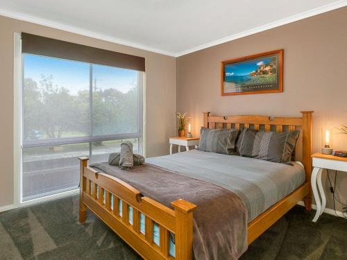 - une chambre avec un lit et une grande fenêtre dans l'établissement Red Rocks Villa, à Cowes