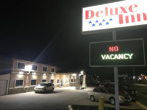 a no vacancy sign in front of a building at night at Deluxe Inn Nebraska City in Nebraska City