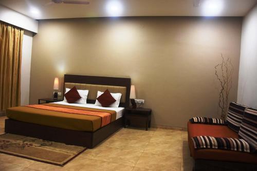 a hotel room with a bed and a couch at Dew Drops Boutique Retreat in Igatpuri