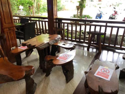 a room with two tables and chairs and a balcony at Hugpua Hotel in Nan