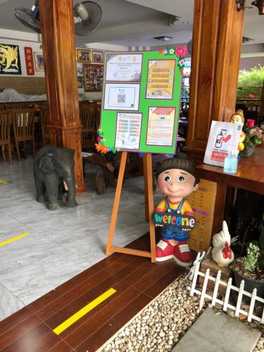 a doll standing next to a sign in a restaurant at Hugpua Hotel in Nan
