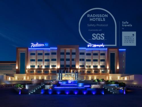 a hotel with blue lights in front of a building at Radisson Blu Hotel & Resort, Sohar in Sohar