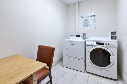 a laundry room with a washing machine and a table at Holiday Inn Express and Suites Three Rivers by IHG in Three Rivers