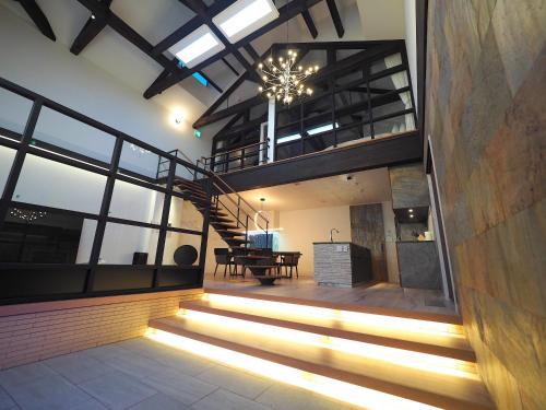 a house with a staircase and a dining room at Pres de La Mer in Hakodate