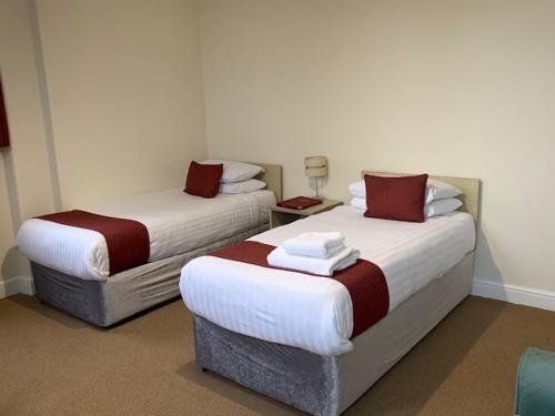 two beds in a hotel room with at Hinsley Hall in Leeds