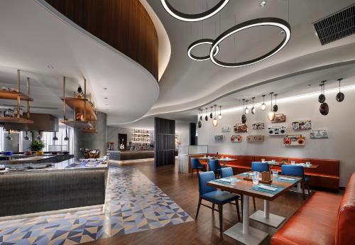 a restaurant with a table and chairs and a bar at Hard Rock Hotel Dalian in Dalian