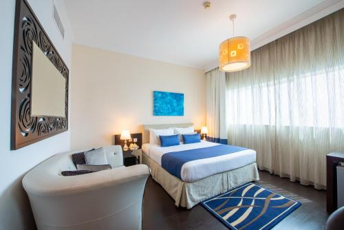 a hotel room with a bed and a couch at First Central Hotel Suites in Dubai