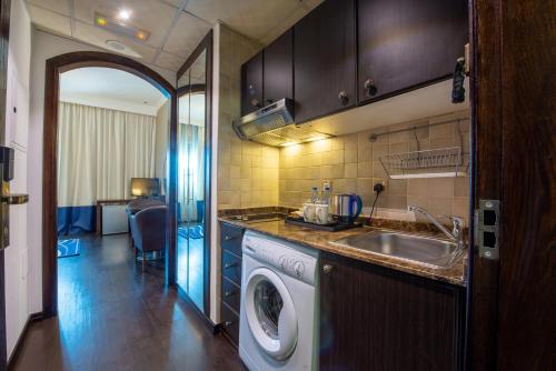 a kitchen with a washing machine and a sink at First Central Hotel Suites in Dubai