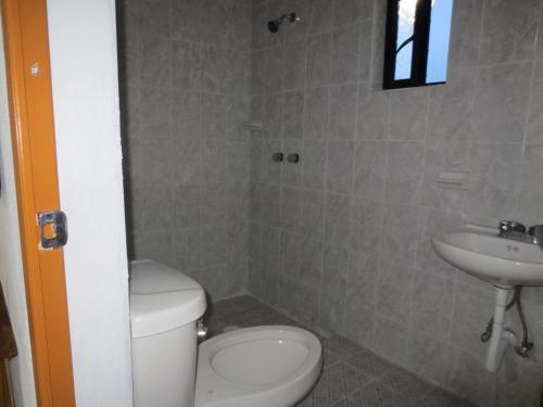 a bathroom with a toilet and a sink at Hotel Chely in Bernal