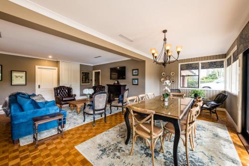 a dining room and living room with a blue couch at Hedge House - luxury, space, style, great location in Toowoomba