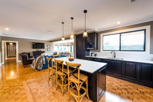 cocina y sala de estar con mesa y sillas en Hedge House - luxury, space, style, great location, en Toowoomba