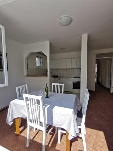 Un comedor con mesa y sillas y una cocina. en Apartmani Marko, en Pale