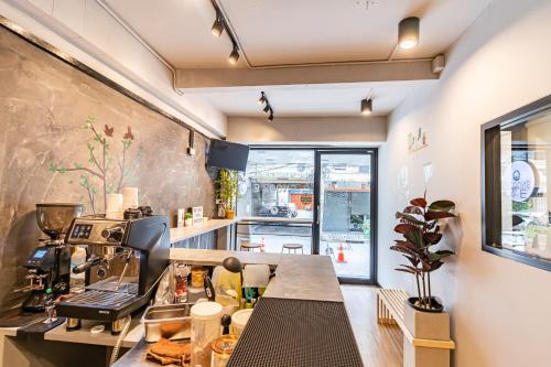 una cucina con bancone e macchinetta del caffè di Snoozzze Hostel ใกล้รถไฟฟ้า ย่านบางรัก a Bangkok