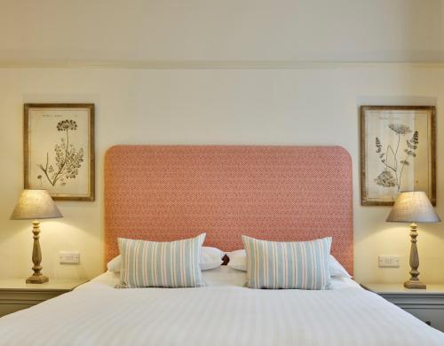 a bedroom with a large white bed with two lamps at The George in South Molton