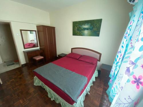 a bedroom with a bed with a red blanket at Marina Apartment 3R2B in Kampong Baharu